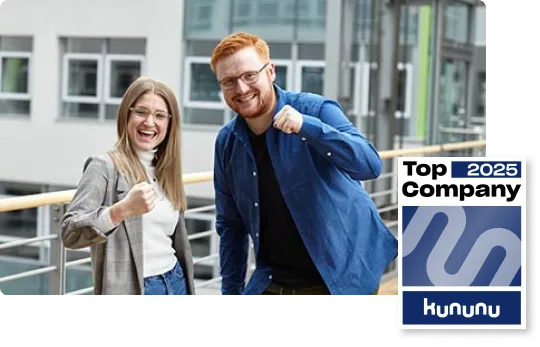 Zwei lächelnde Personen zeigen Daumen hoch vor modernem Bürogebäude, daneben ein "Top Company 2025" Siegel von kununu.